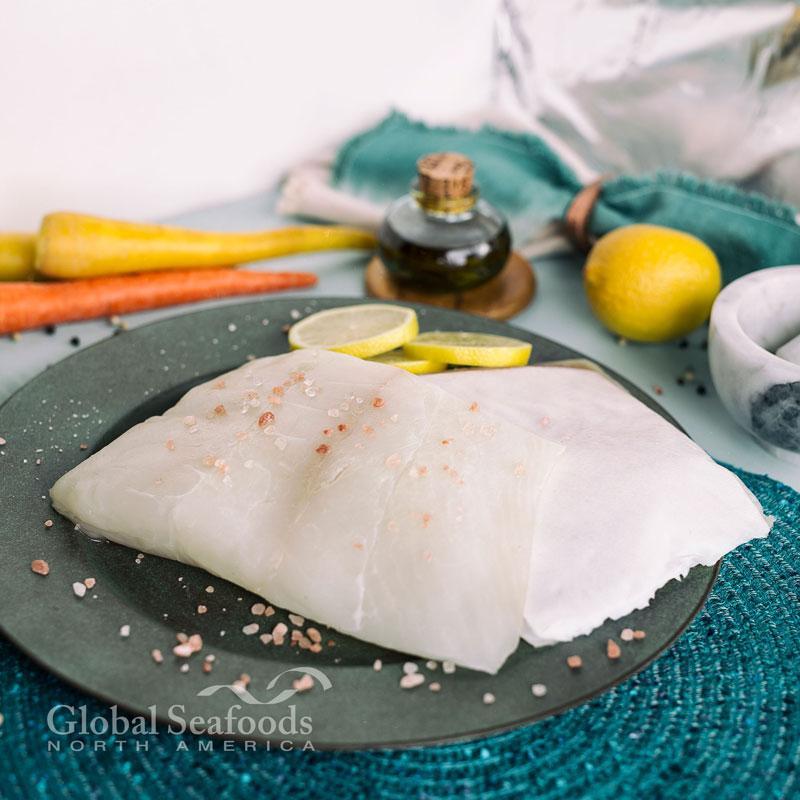 Grilled Pacific Halibut fillet served with roasted vegetables and lemon garnish.